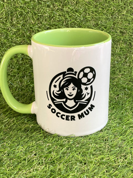 White mug with green handle and green inside with a soccer mum logo and text.